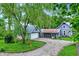 Charming home with a gravel driveway and lush lawn, shaded by mature trees and an attached garage at 9237 N 500 W, Fountaintown, IN 46130
