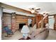 Cozy living room with exposed log walls, brick fireplace, comfortable furnishings and an open staircase at 9237 N 500 W, Fountaintown, IN 46130