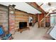 A comfortable living area with exposed log walls, a brick chimney, and an open staircase at 9237 N 500 W, Fountaintown, IN 46130