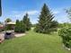 Spacious backyard showing a green lawn and mature trees with a patio and grill at 9302 N Bayland Dr, McCordsville, IN 46055