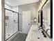 Modern bathroom featuring dual sinks, a walk-in shower with glass door, and a white door at 9302 N Bayland Dr, McCordsville, IN 46055