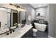 Elegant bathroom featuring a double vanity, freestanding tub, and sleek black fixtures, offering a spa-like experience at 9302 N Bayland Dr, McCordsville, IN 46055