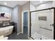 Bathroom features a tub, sleek gray tile flooring, and a frameless glass shower at 9302 N Bayland Dr, McCordsville, IN 46055