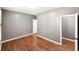 Bedroom with hardwood floors and neutral walls with white trim, featuring a white door at 9302 N Bayland Dr, McCordsville, IN 46055