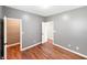 Bedroom featuring hardwood floors, neutral walls, and white doors leading to closet space at 9302 N Bayland Dr, McCordsville, IN 46055
