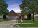 Charming brick home with a manicured front yard, mature trees, and attached garage at 9302 N Bayland Dr, McCordsville, IN 46055