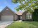 Charming brick home featuring a well-manicured lawn and a two-car garage at 9302 N Bayland Dr, McCordsville, IN 46055