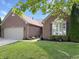 Charming brick home featuring a well-manicured lawn, flowers and a two-car garage at 9302 N Bayland Dr, McCordsville, IN 46055