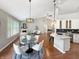 Open concept living and dining with stone fireplace, modern light fixtures, and a white kitchen with an island at 9302 N Bayland Dr, McCordsville, IN 46055