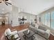 Open-concept living area showcases hardwood floors connecting the kitchen and living spaces, bathed in sunlight from shuttered windows at 9302 N Bayland Dr, McCordsville, IN 46055