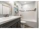 Bright bathroom with a black vanity, single sink, and tiled shower at 9520 Settlement W Dr, Indianapolis, IN 46250