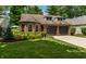 Charming brick home with an attached garage and a beautifully landscaped front yard with colorful flowers at 9520 Settlement W Dr, Indianapolis, IN 46250
