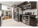 Modern kitchen with stainless steel appliances, dark cabinetry, and light tile flooring at 9520 Settlement W Dr, Indianapolis, IN 46250