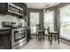 Eat-in kitchen with stainless steel appliances, gray cabinets, and lots of natural light at 9520 Settlement W Dr, Indianapolis, IN 46250