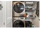 Convenient laundry closet with stacked washer and dryer, plus shelving for storage at 9520 Settlement W Dr, Indianapolis, IN 46250
