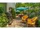 Charming backyard patio featuring yellow wicker chairs, a grill, and vibrant green foliage shaded by blue umbrellas at 9520 Settlement W Dr, Indianapolis, IN 46250