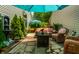 Inviting stone patio featuring comfortable wicker seating, a decorative water feature, and shaded by a blue umbrella at 9520 Settlement W Dr, Indianapolis, IN 46250