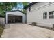 View of the home's detached garage with open door and concrete driveway at 953 E 34Th St, Indianapolis, IN 46205
