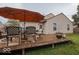 Wooden deck area with patio furniture and large orange umbrella for outdoor dining at 982 Ramsgate Rd, Greenwood, IN 46143