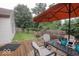 Outdoor deck with an umbrella, chairs, a dining table, and a spacious grassy yard at 982 Ramsgate Rd, Greenwood, IN 46143
