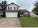 Two-story home featuring a two-car garage, well-kept lawn, brick and vinyl siding, and mature landscaping at 982 Ramsgate Rd, Greenwood, IN 46143