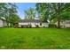 Expansive backyard, with green grass, privacy fence, mature trees, and a back deck at 99 Old Trail Dr, Bargersville, IN 46106