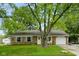 A well-maintained brick home with mature trees, a front lawn, and attached one car garage at 99 Old Trail Dr, Bargersville, IN 46106