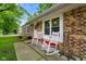 Welcoming front porch with white rocking chairs, brick facade, and verdant landscaping at 99 Old Trail Dr, Bargersville, IN 46106