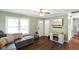 Cozy living room featuring a decorative fireplace, dark wood floors, and abundant natural light at 99 Old Trail Dr, Bargersville, IN 46106