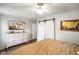 A bedroom features a television, hardwood floors, modern lighting and stylish sliding closet doors at 99 Old Trail Dr, Bargersville, IN 46106