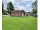 Brick house showcases a spacious backyard with a covered patio, perfect for outdoor living at 100 Justin Dr, Mooresville, IN 46158