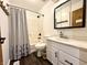 Bathroom featuring wood-look flooring, shower with curtain, sink with cabinet storage, and mirror at 100 Justin Dr, Mooresville, IN 46158