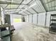 Bright interior view of the outbuilding featuring shelving, storage, and ample open space at 100 Justin Dr, Mooresville, IN 46158