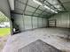 Interior view of the outbuilding with an open garage door and large overhead lighting at 100 Justin Dr, Mooresville, IN 46158