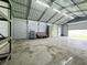 Spacious outbuilding interior offers shelving, cabinet, and open floor plan with overhead lighting at 100 Justin Dr, Mooresville, IN 46158