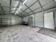 View of the outbuilding interior, featuring metal framing, open door, and concrete floor at 100 Justin Dr, Mooresville, IN 46158