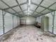 The spacious outbuilding interior has a concrete floor, shelving, cabinet, and ample lighting at 100 Justin Dr, Mooresville, IN 46158