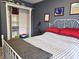 Bedroom with closet, gray walls, white metal bedframe with red linens, and carpeted floor at 1027 Springway Dr, Shelbyville, IN 46176