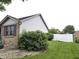 Back yard featuring a lush lawn and privacy provided by mature shrubs and a pristine white fence at 1027 Springway Dr, Shelbyville, IN 46176