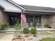 Charming brick home featuring an inviting front porch and well-manicured landscaping at 1027 Springway Dr, Shelbyville, IN 46176