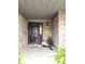 Inviting front porch with brick detail, 'Welcome' mat, and decorative potted plants at 1027 Springway Dr, Shelbyville, IN 46176