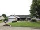 Well-kept home with a lush front lawn, tasteful landscaping, and mature trees at 1027 Springway Dr, Shelbyville, IN 46176
