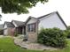 Charming brick home with well-maintained lawn, rock garden, and an American flag at 1027 Springway Dr, Shelbyville, IN 46176
