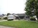 Charming single-story brick home with well-maintained lawn, mature tree, and attached garage at 1027 Springway Dr, Shelbyville, IN 46176