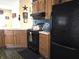 The kitchen features dark appliances, warm cabinets, and the same tiled flooring as seen elsewhere in the home at 1027 Springway Dr, Shelbyville, IN 46176