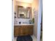 Bathroom with wood cabinets, white countertops, and wall mirror at 1027 Springway Dr, Shelbyville, IN 46176