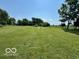 Large open backyard with lush grass and a fire pit area, ideal for outdoor enjoyment at 10727 N Shupe Rd, Monrovia, IN 46157