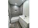 Modern bathroom featuring gray tile, bathtub, shower, and white sink with cabinetry at 10727 N Shupe Rd, Monrovia, IN 46157