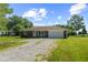 Charming one-story home with an attached garage, brick detailing, and covered porch on a large lot with a gravel driveway at 10727 N Shupe Rd, Monrovia, IN 46157