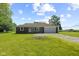 Single-story house with a brick accent, covered entry, attached garage, and expansive green lawn under a blue sky with clouds at 10727 N Shupe Rd, Monrovia, IN 46157